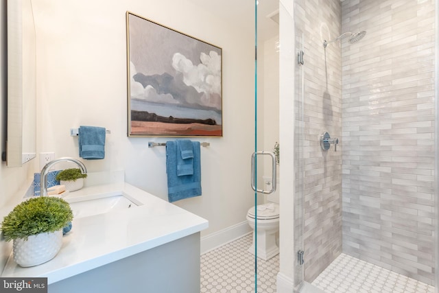 full bathroom with baseboards, toilet, a shower stall, and vanity