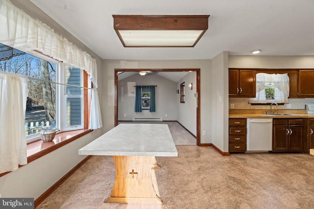 kitchen featuring light countertops, white dishwasher, a sink, and a wealth of natural light