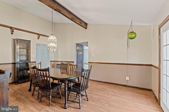 dining room featuring vaulted ceiling with beams, light wood-style flooring, and baseboards