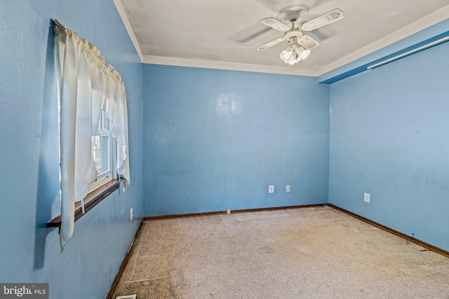 spare room featuring crown molding, carpet, ceiling fan, and baseboards