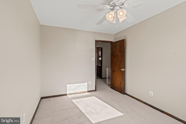 spare room featuring a ceiling fan, carpet, visible vents, and baseboards