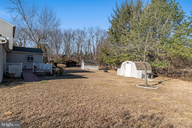 view of yard featuring an outbuilding, a deck, and a storage shed