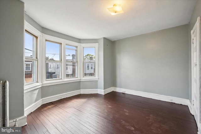 unfurnished room featuring dark wood finished floors and baseboards