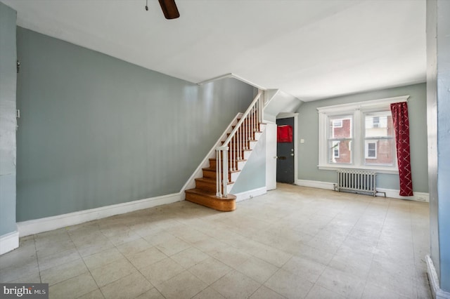 interior space with a ceiling fan, baseboards, stairs, tile patterned floors, and radiator