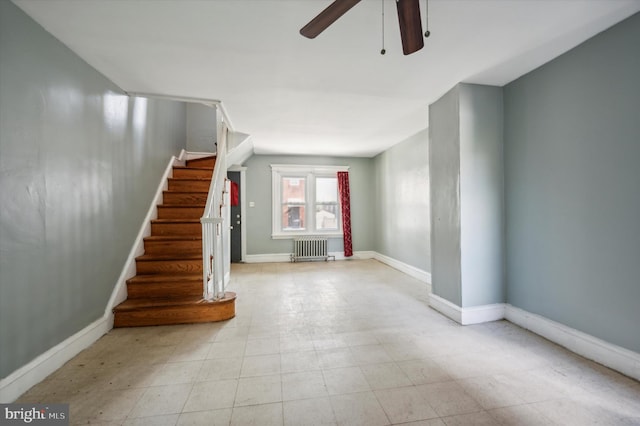 interior space featuring a ceiling fan, radiator, and baseboards