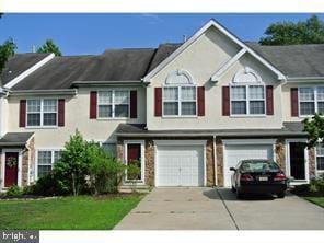 townhome / multi-family property featuring a garage and driveway