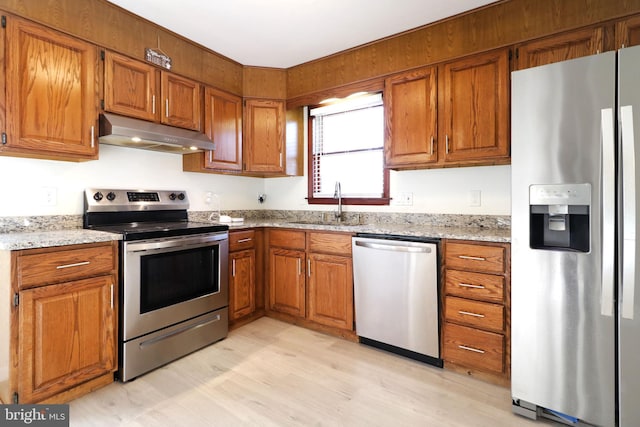 246 First Ave, State College, PA 16801 - kitchen featuring light stone counters, under cabinet range hood, a sink, appliances with stainless steel finishes, and brown cabinets