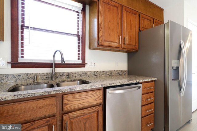 246 First Ave, State College, PA 16801 - kitchen featuring stainless steel appliances, brown cabinetry, a sink, and light stone counters