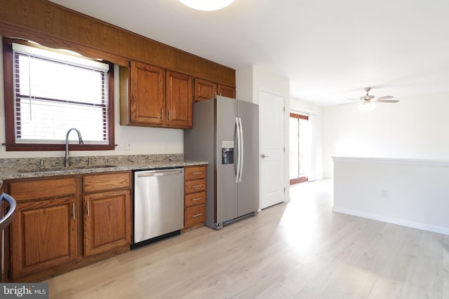 246 First Ave, State College, PA 16801 - kitchen featuring light stone counters, a sink, appliances with stainless steel finishes, light wood-type flooring, and brown cabinetry