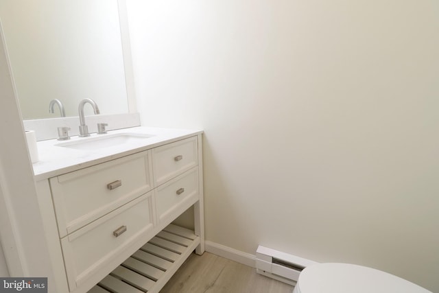 246 First Ave, State College, PA 16801 - bathroom featuring toilet, a baseboard heating unit, vanity, wood finished floors, and baseboards