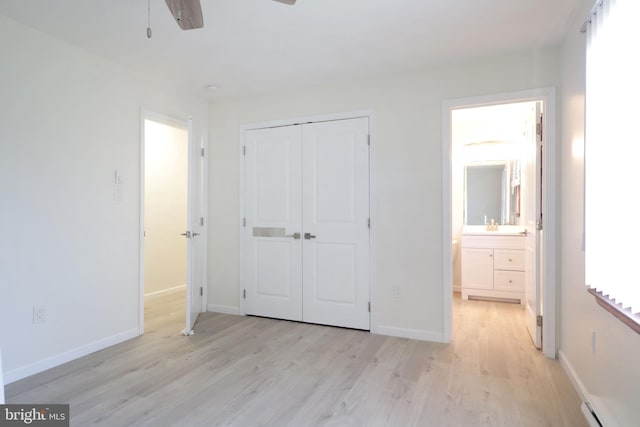 246 First Ave, State College, PA 16801 - unfurnished bedroom with connected bathroom, a baseboard heating unit, baseboards, light wood-style floors, and a closet