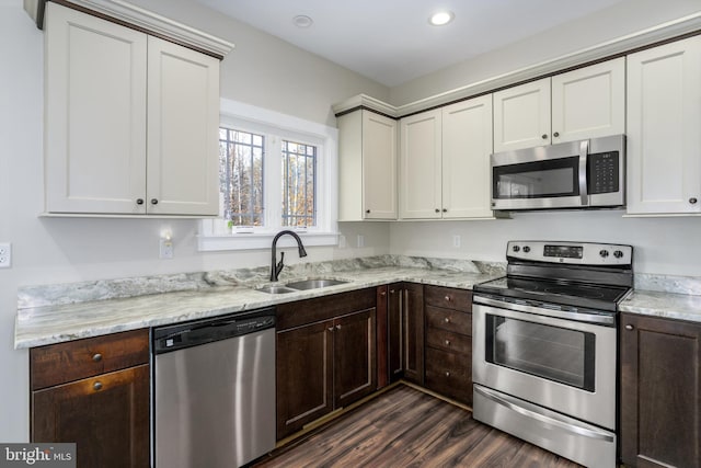 kitchen featuring dark wood-style flooring, dark brown cabinets, appliances with stainless steel finishes, and a sink