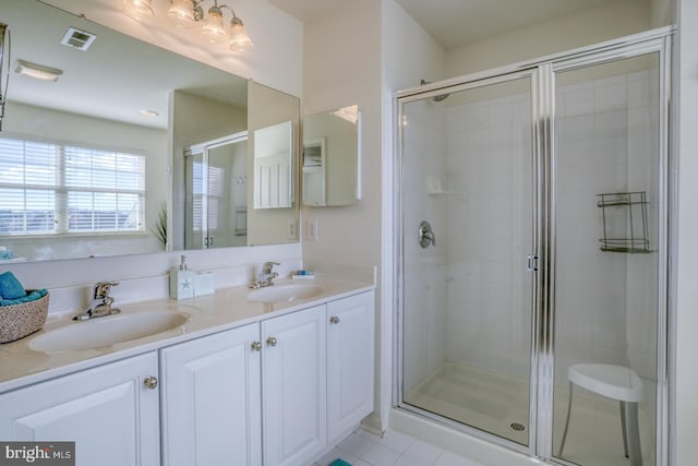 bathroom featuring double vanity, a sink, visible vents, and a shower stall