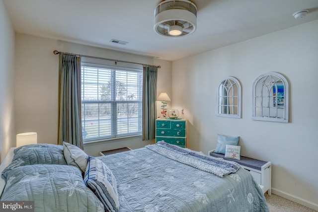 bedroom featuring visible vents, light carpet, and baseboards