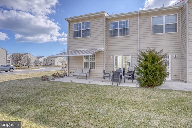 rear view of house featuring a patio area and a lawn