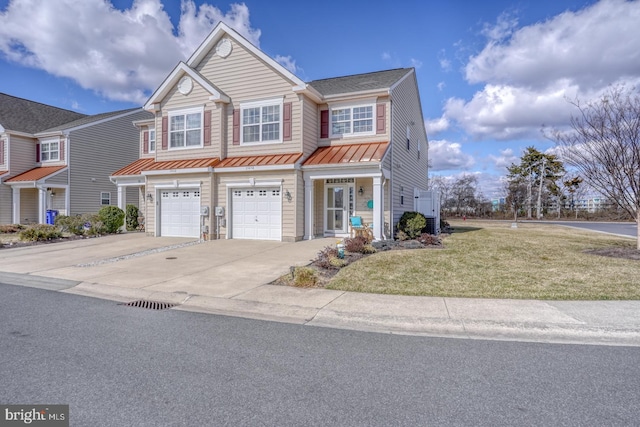 view of front of home featuring driveway, a garage, metal roof, a standing seam roof, and a front lawn