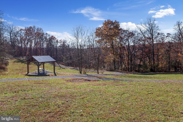 view of yard featuring a view of trees and a gazebo