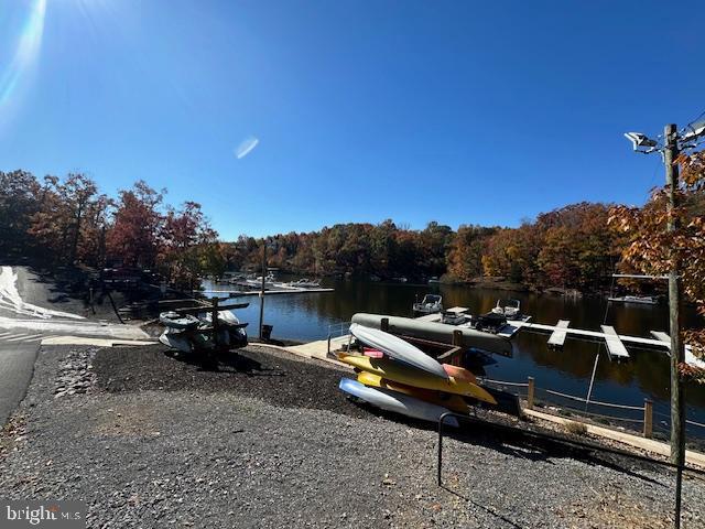 dock area featuring a water view and a view of trees