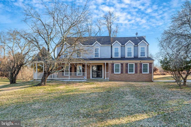 view of front of property with brick siding, covered porch, and a front yard