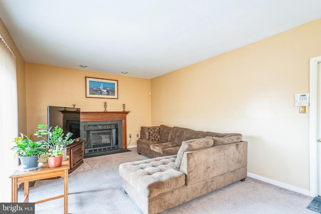 living area featuring baseboards, a fireplace with flush hearth, and carpet flooring