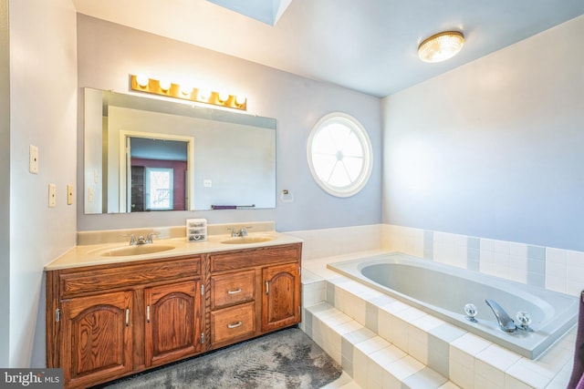 full bathroom with double vanity, a garden tub, and a sink