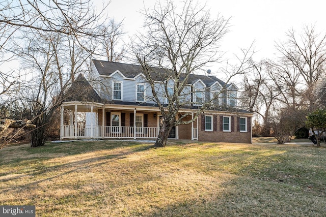 cape cod house with brick siding, a porch, and a front yard