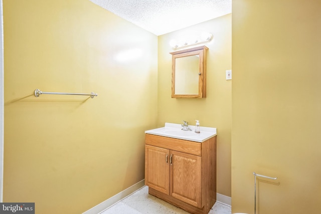 bathroom with vanity, tile patterned floors, baseboards, and a textured ceiling