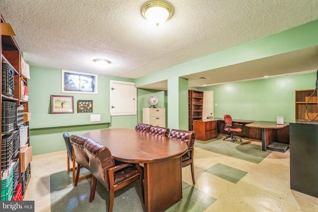 dining space with tile patterned floors, baseboards, and a textured ceiling