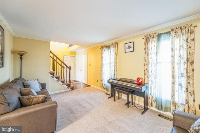 living area featuring carpet, baseboards, visible vents, ornamental molding, and stairs