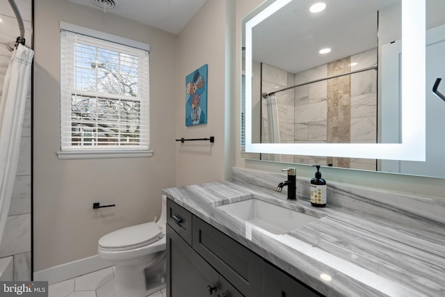 bathroom with recessed lighting, toilet, a tile shower, vanity, and baseboards