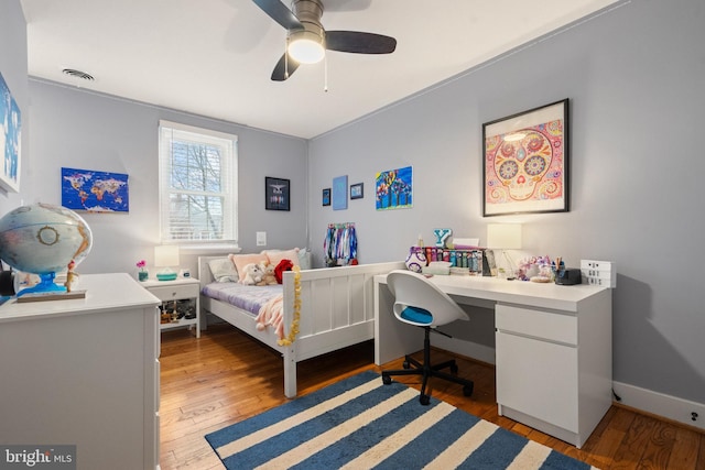 bedroom with light wood-style floors, visible vents, ceiling fan, and baseboards