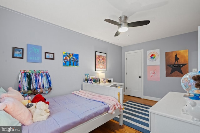 bedroom with ceiling fan, baseboards, and wood finished floors