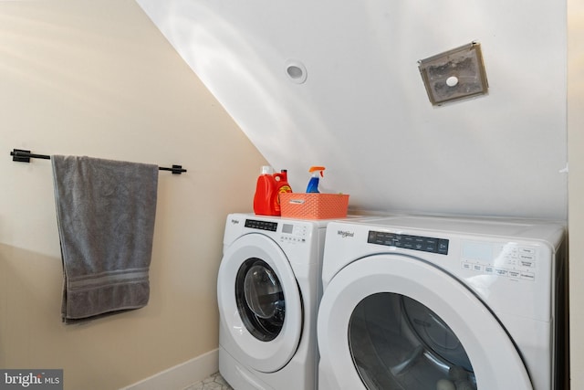 washroom with laundry area, washing machine and dryer, and baseboards