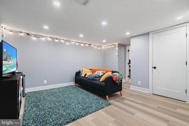 living area with recessed lighting, baseboards, visible vents, and light wood finished floors