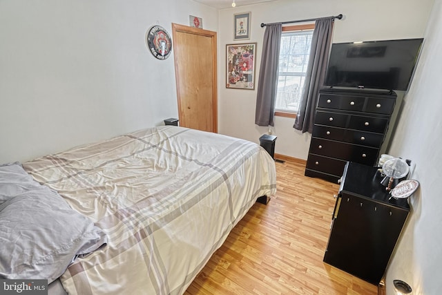 bedroom with baseboards and light wood finished floors