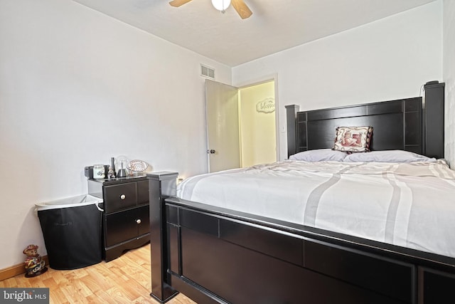 bedroom with baseboards, light wood-style flooring, visible vents, and a ceiling fan