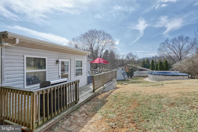 view of yard with a deck, a storage shed, an outdoor structure, and an outdoor pool