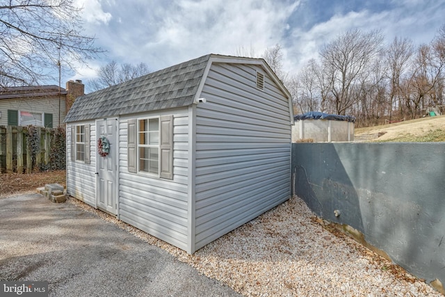 view of shed featuring fence