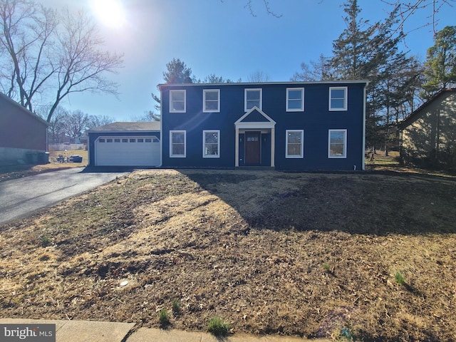 colonial home with an attached garage and driveway