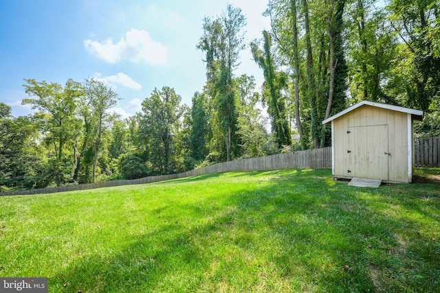 view of yard with fence, an outdoor structure, and a storage unit