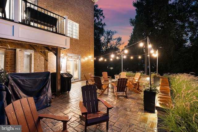 view of patio / terrace with a balcony, a grill, and a fire pit