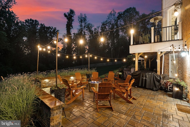 view of patio with a fire pit, area for grilling, and a balcony