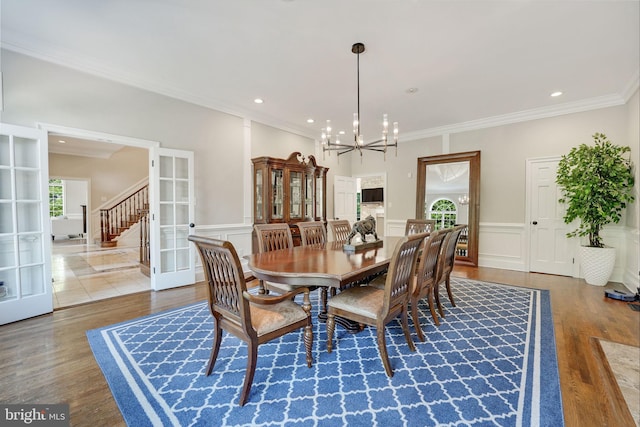 dining room featuring a chandelier, french doors, wainscoting, and wood finished floors