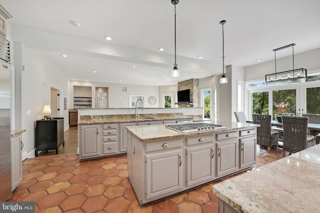 kitchen with a large island, recessed lighting, stainless steel gas stovetop, open floor plan, and a sink