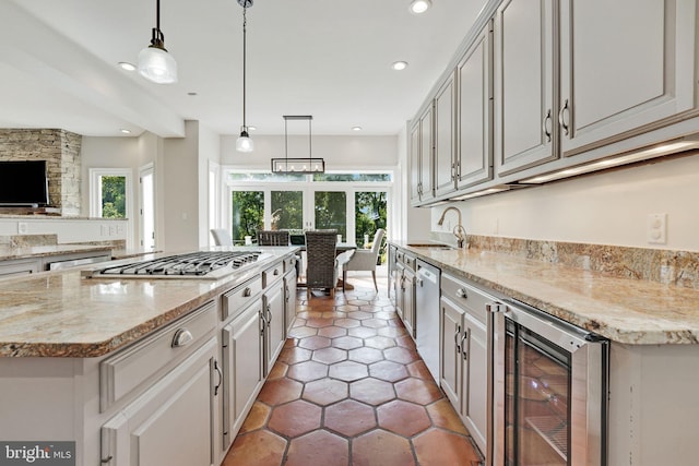 kitchen featuring appliances with stainless steel finishes, wine cooler, plenty of natural light, and a sink