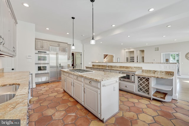 kitchen with open shelves, a spacious island, recessed lighting, hanging light fixtures, and built in appliances