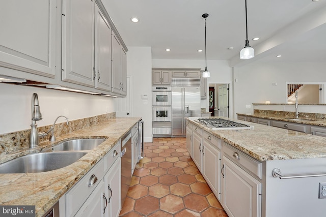 kitchen featuring stainless steel appliances, recessed lighting, a sink, and a kitchen island