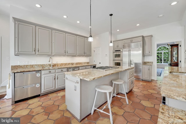 kitchen with a kitchen island, stainless steel appliances, a sink, and recessed lighting