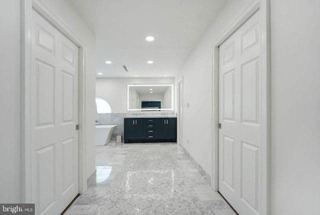 full bathroom with recessed lighting, vanity, baseboards, a freestanding bath, and marble finish floor