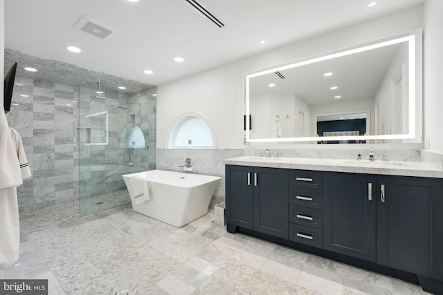 full bath with a freestanding tub, tiled shower, a sink, and double vanity